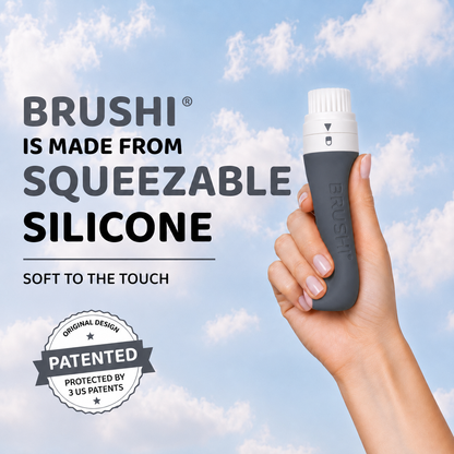 A hand holding a Brushi squeezeable silicone sunscreen applicator against a blue sky with clouds background. Text on the image reads 'BRUSHI IS MADE FROM SQUEEZABLE SILICONE' and 'SOFT TO THE TOUCH', with a 'PATENTED' badge at
